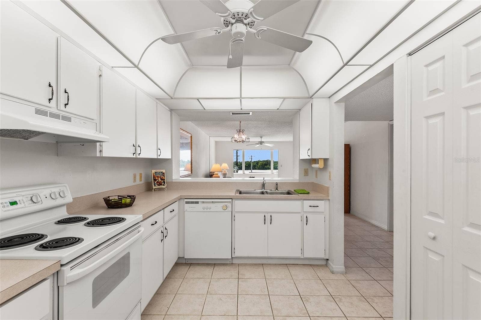 1776 6TH STREET NW, #304, Winter Haven, FL 33881 KITCHEN WITH PASS THRU TO DINING AREA. PANTRY CLOSET ON RIGHT.