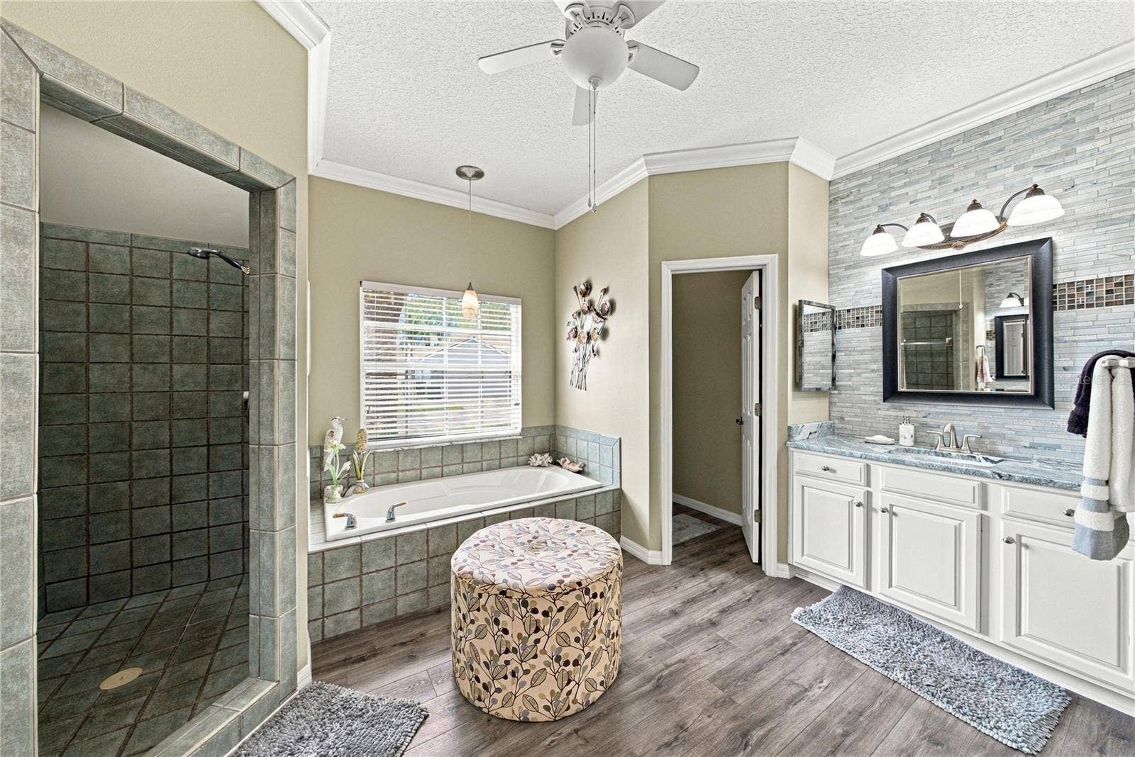 4232 DORNOCH DRIVE, Lake Wales, FL 33859 The primary bath has stone accent walls, crown molding, ceiling fan with light, and a privacy toilet room.