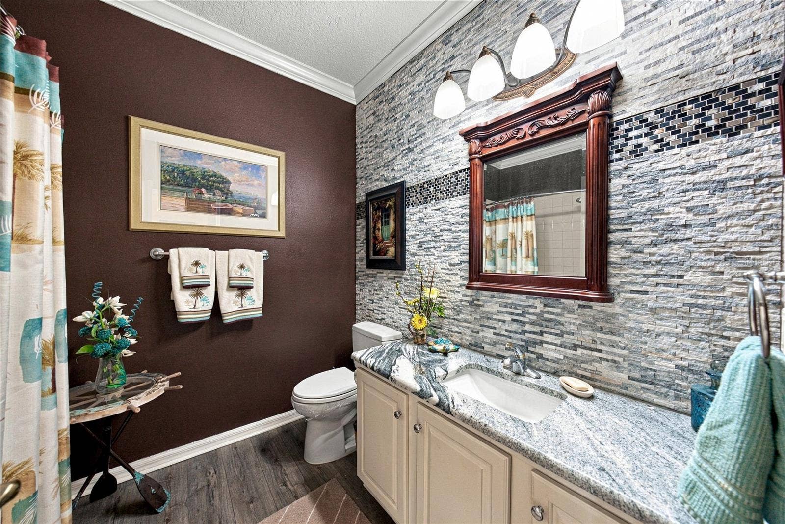 4232 DORNOCH DRIVE, Lake Wales, FL 33859 The recently remodeled guest bath has an elongated stool, stone counters, upgraded plumbing and lighting fixtures. The stone wall with accents adds to the richness of this space.