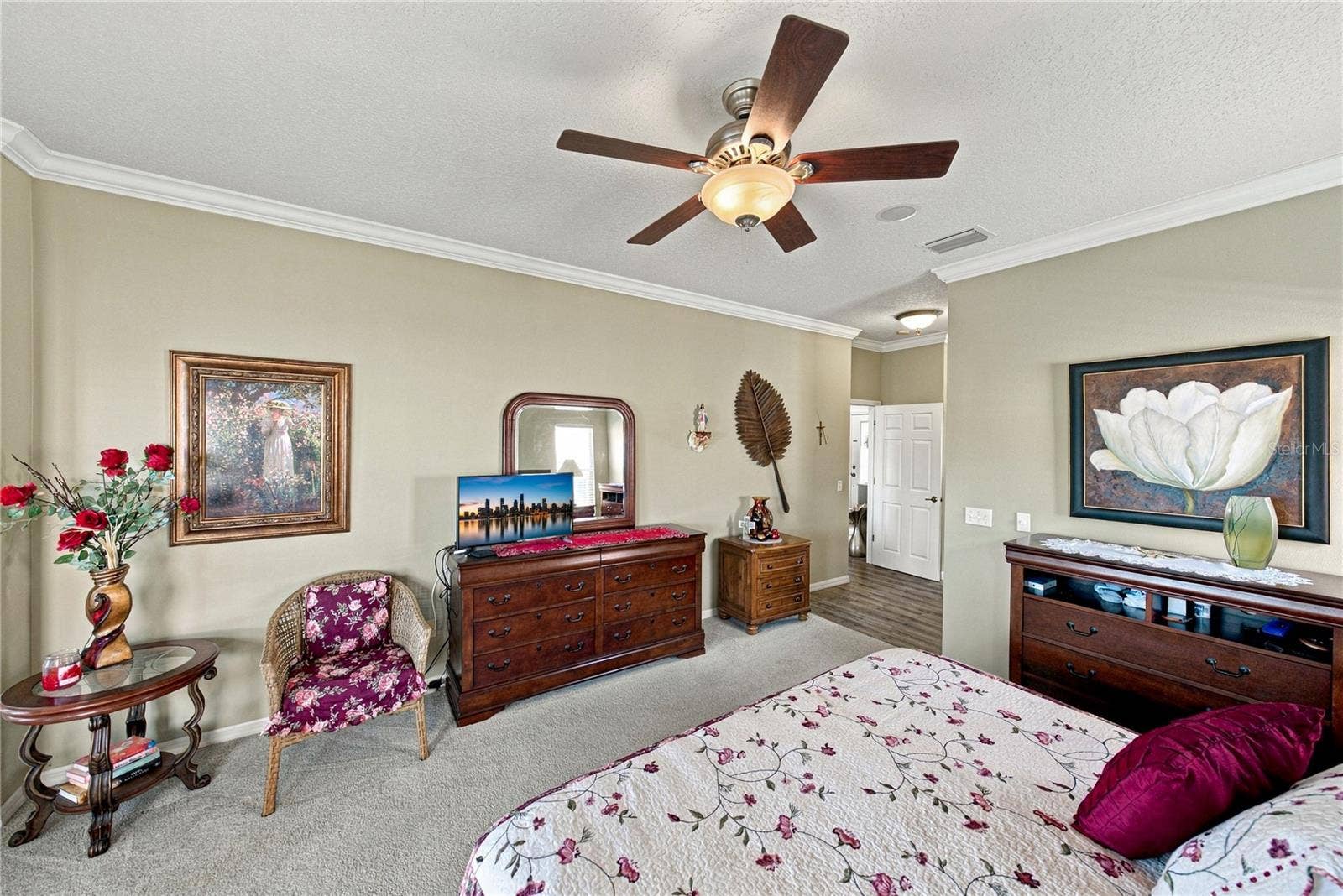 4232 DORNOCH DRIVE, Lake Wales, FL 33859 The primary bedroom has a designer ceiling fan with light, crown molding, and quality carpeting.