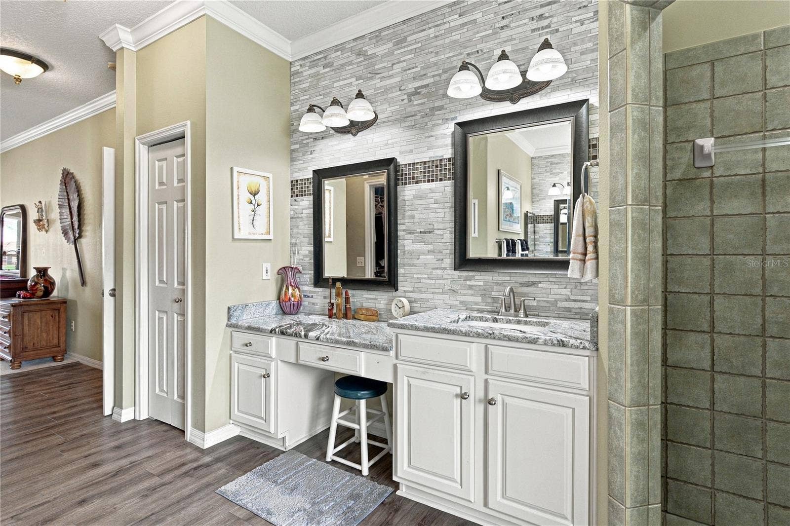4232 DORNOCH DRIVE, Lake Wales, FL 33859 The east vanity has stone countertops, a makeup area, elevated sink, stone wall with accents, upgrades lighting and plumbing fixtures.