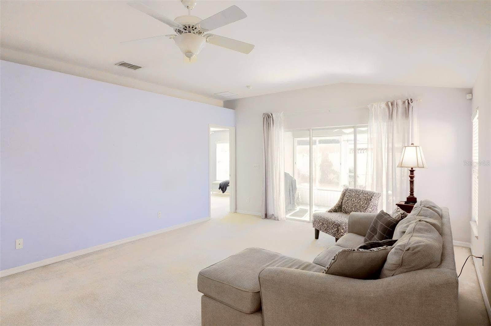 3437 GRENVILLE DRIVE, Winter Haven, FL 33884 Triple sliding glass doors leading to the Florida room, where tranquil garden views create a peaceful setting.