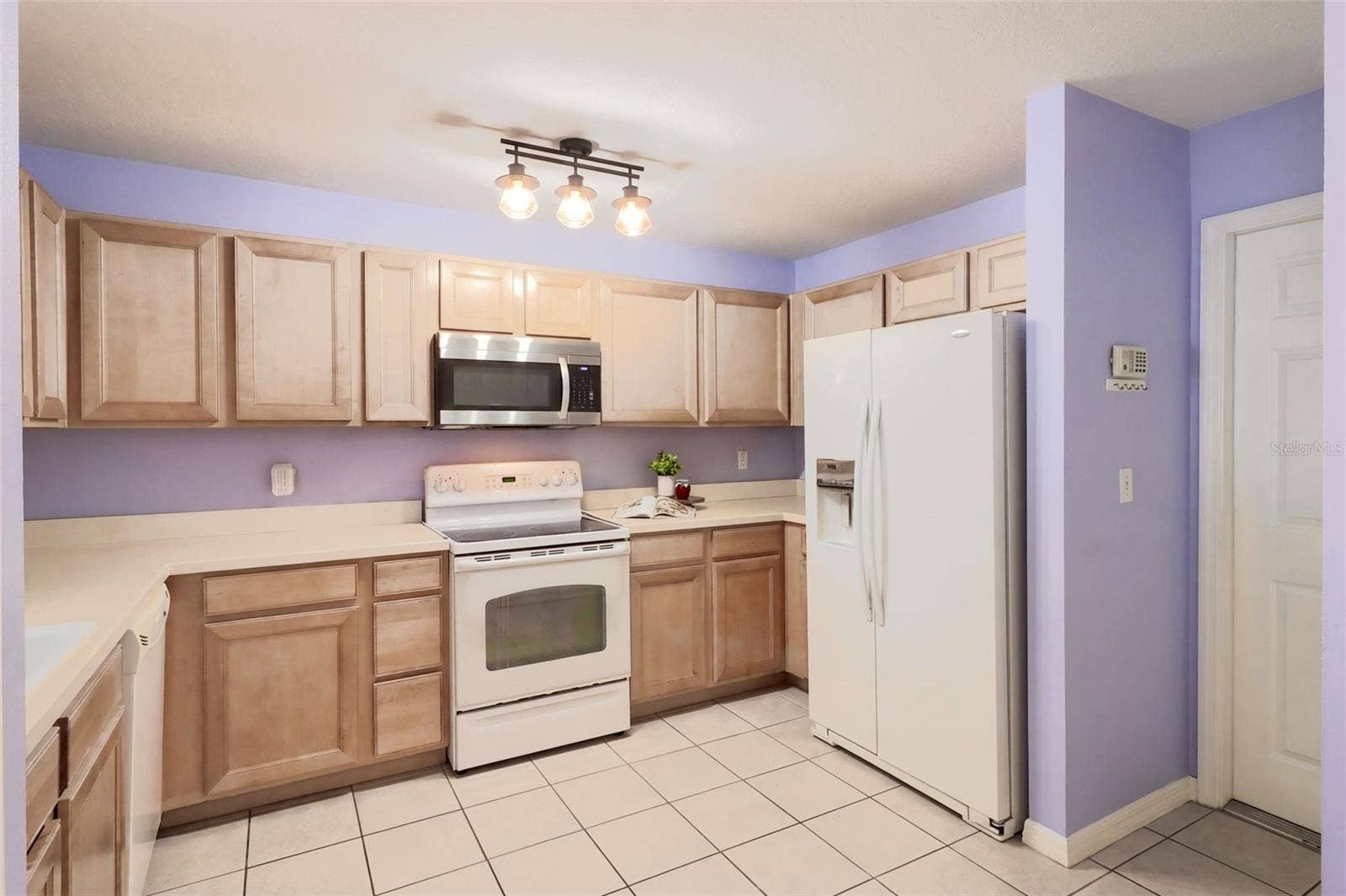 3437 GRENVILLE DRIVE, Winter Haven, FL 33884 The kitchen features maple wood cabinetry, an updated microwave