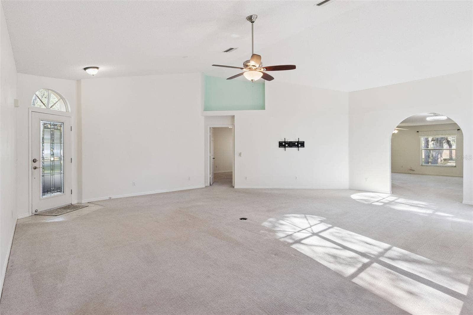 Living Room featuring Vaulted Ceilings and Decorative Planter Shelf