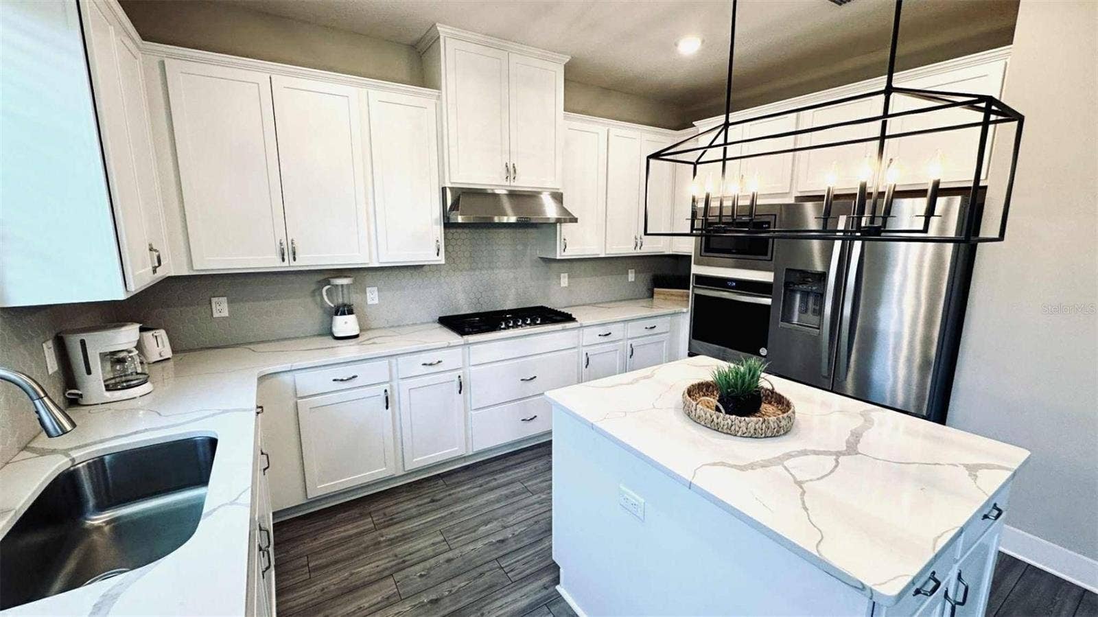 7958 HAVERHILL WAY, Kissimmee, FL 34747 Modern kitchen with granite countertops, stainless-steel appliances, and large island ideal for gatherings.