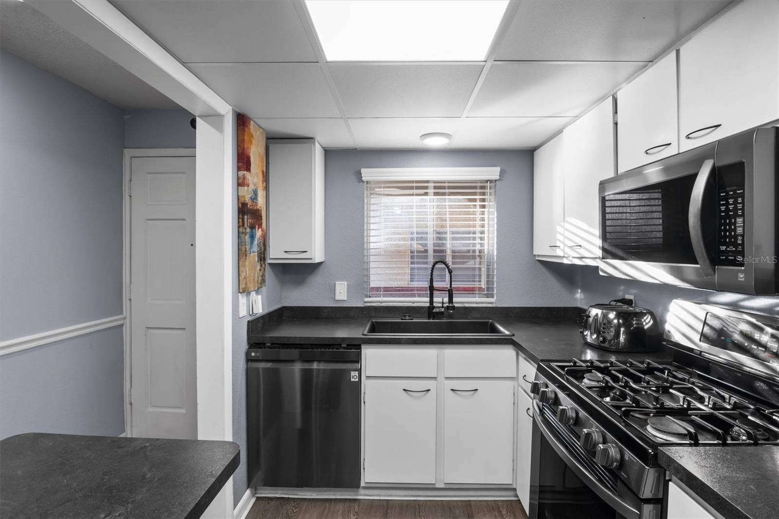 The kitchen has a gas stove and stainless steel appliances