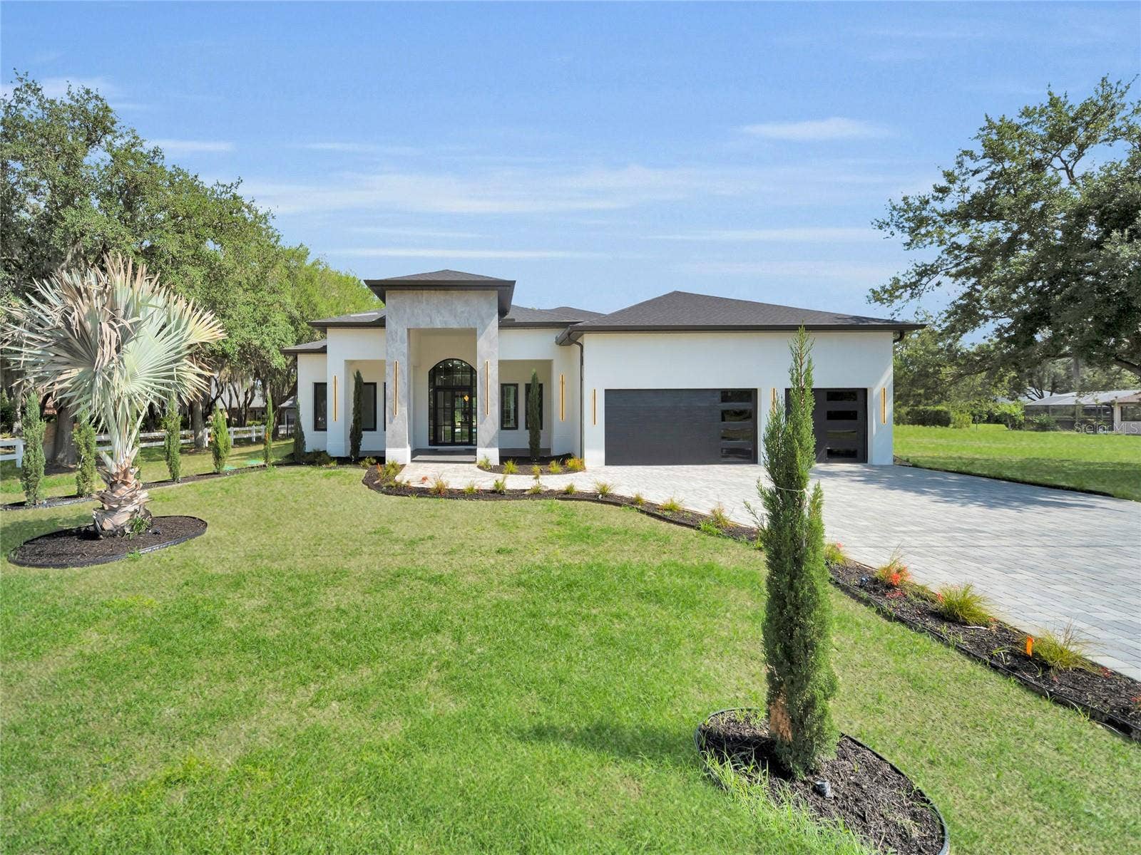 11241 OSWALT ROAD, Clermont, FL 34711 Front elevation with landscaped curb appeal and paver driveway