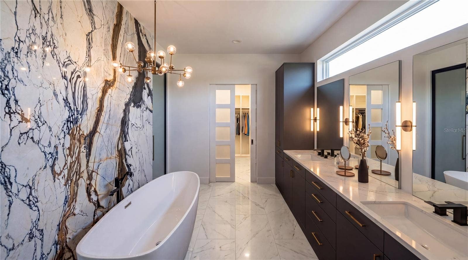 3654 HIDDEN RIVER LANE, Tavares, FL 32778 Primary bath with dual vanities, gorgeous cabinetry, free standing tub and breathtaking feature wall. Large shower