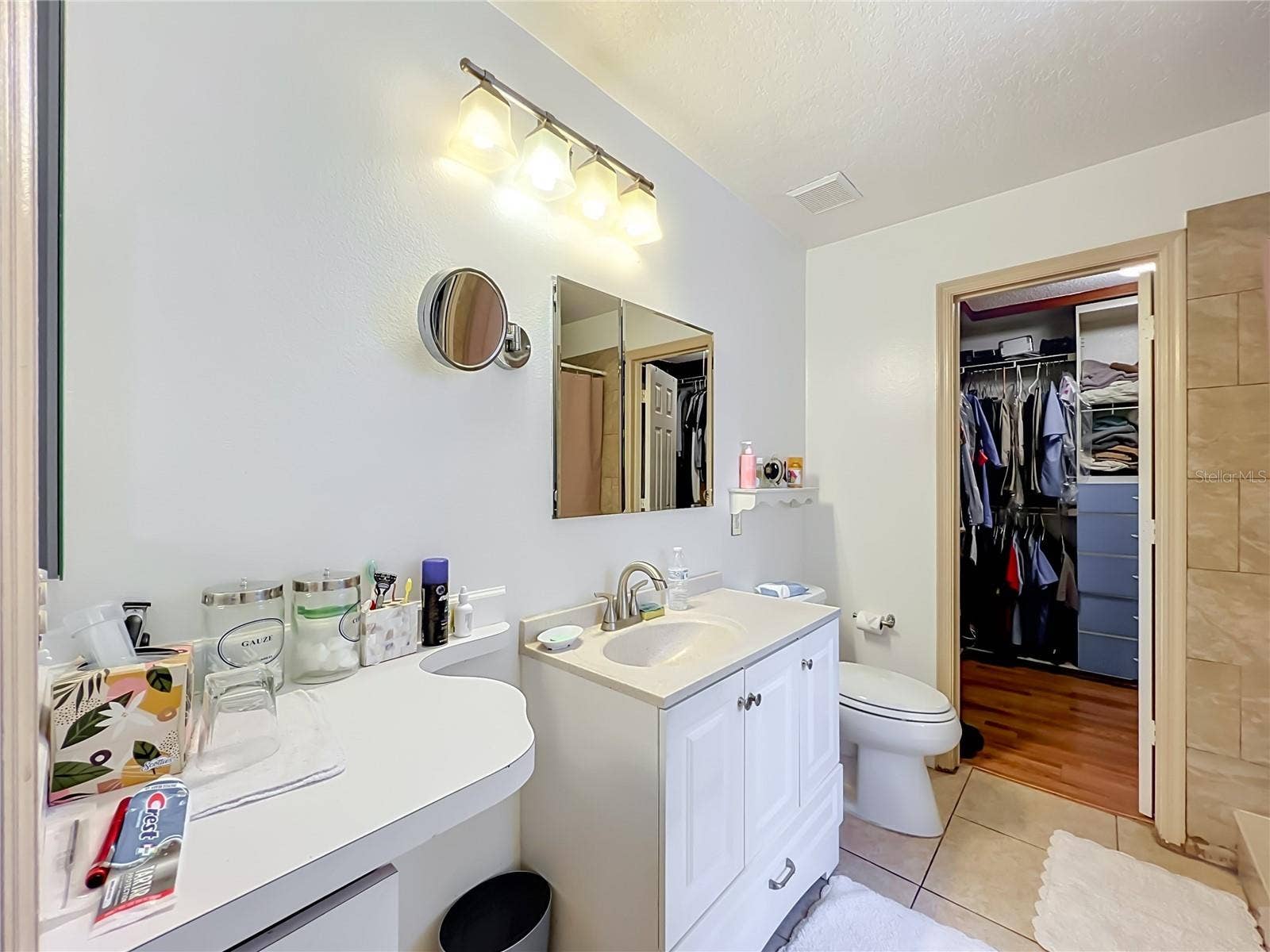 12900 LOS ALAMITOS COURT, Orlando, FL 32837 Primary bathroom with vanity, single sink vanity, toilet and walk in closet