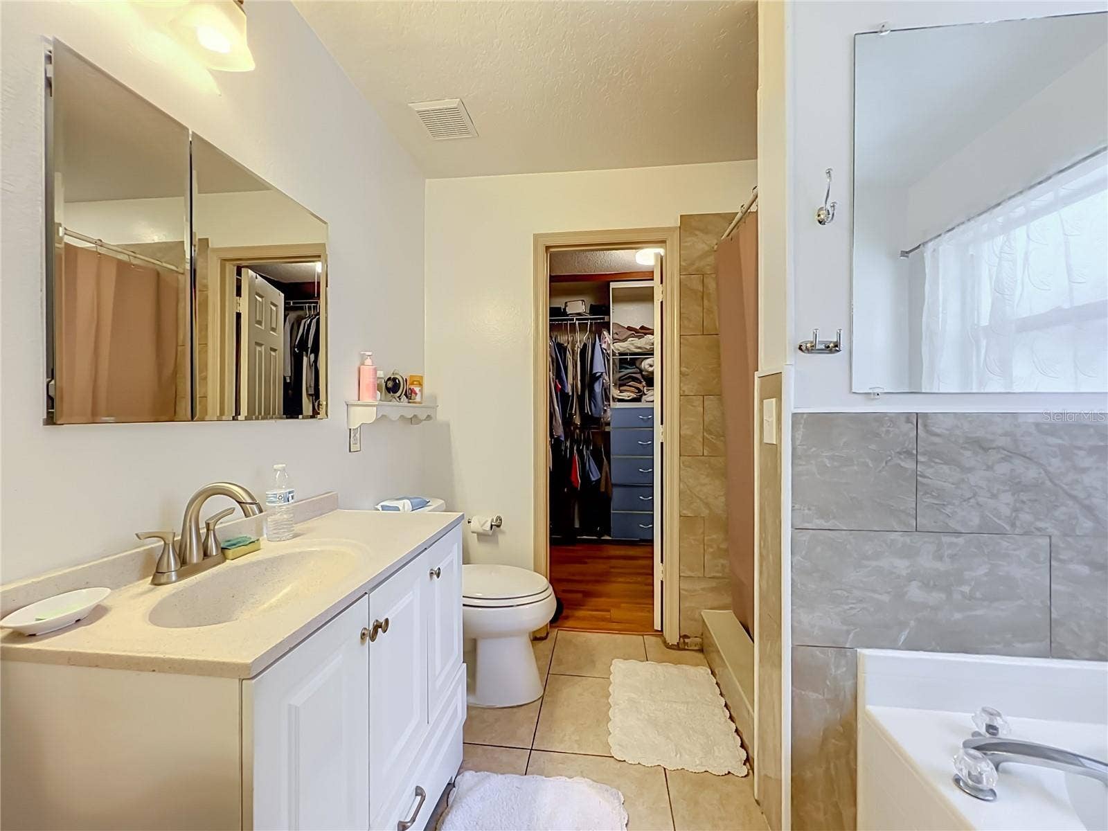 12900 LOS ALAMITOS COURT, Orlando, FL 32837 Primary bath with single sink, vanity, walk in closet, separate shower and garden tub