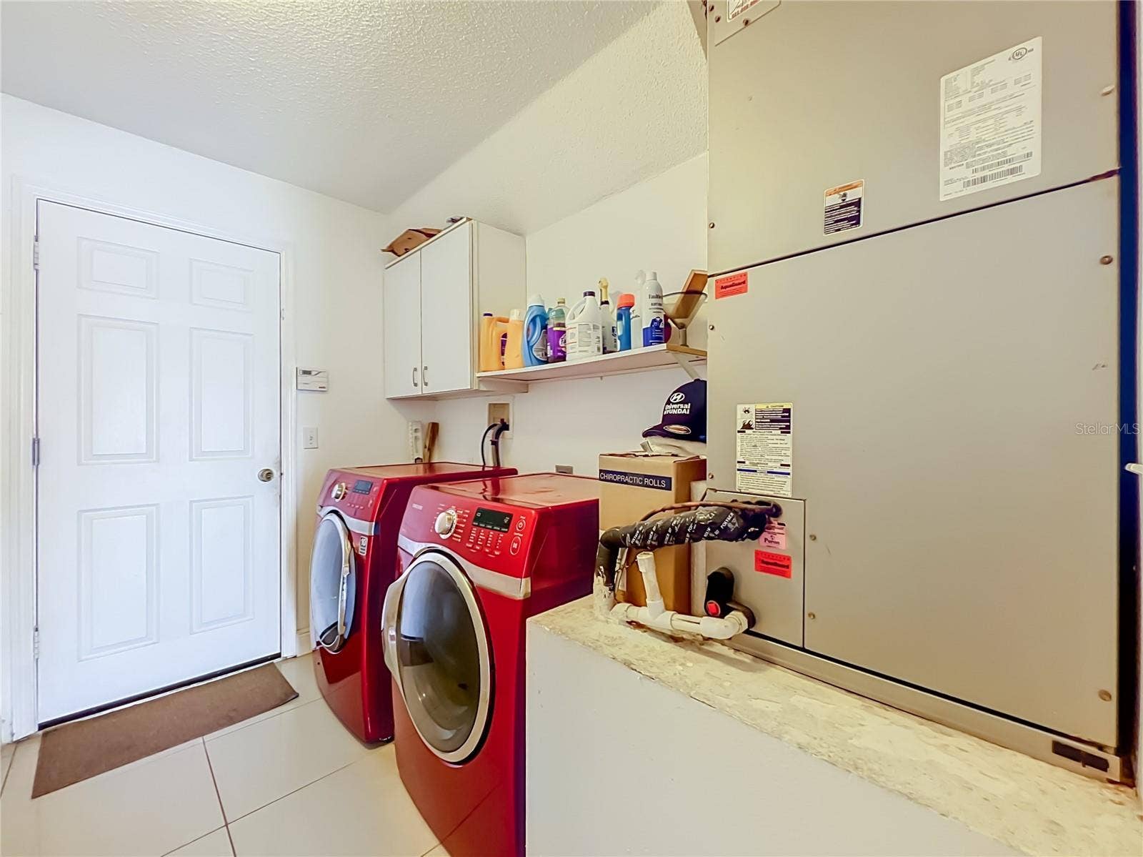 12900 LOS ALAMITOS COURT, Orlando, FL 32837 Off the kitchen is the 1st floor inside laundry room with nice Samsung washer and dryer, storage cabinets and storage shelf. Leading to the attached garage.