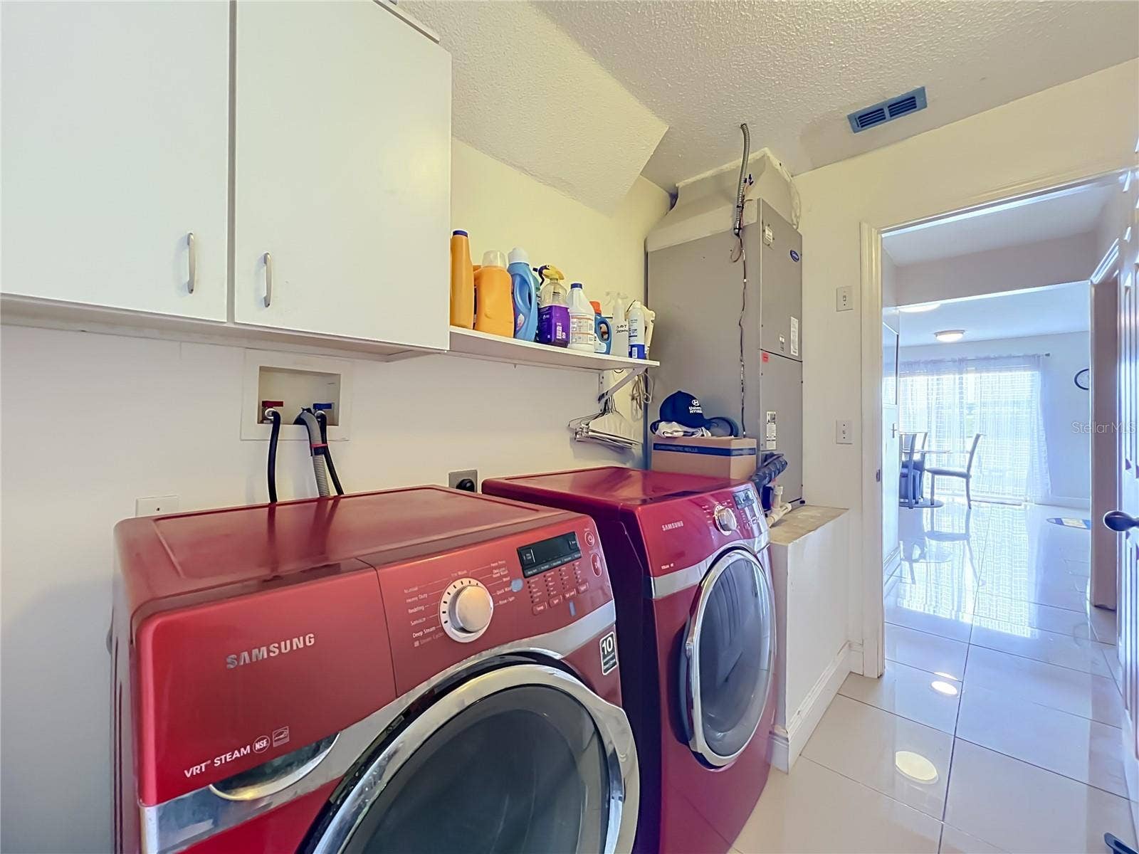 12900 LOS ALAMITOS COURT, Orlando, FL 32837 Off the kitchen is the 1st floor inside laundry room with nice Samsung washer and dryer, storage cabinets and storage shelf