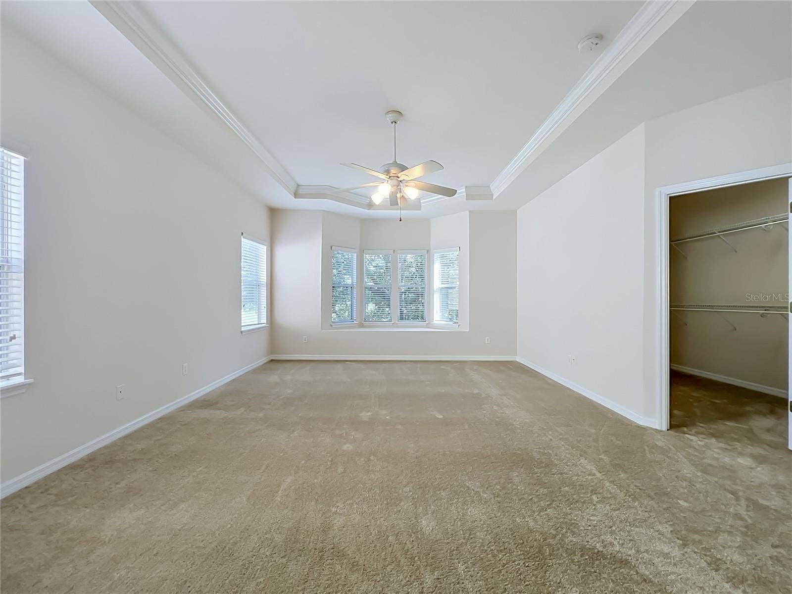 12809 HOLDENBURY LANE, Windermere, FL 34786 Primary bedroom features window seat, ceiling fan, tray ceiling, and large walk-in closet