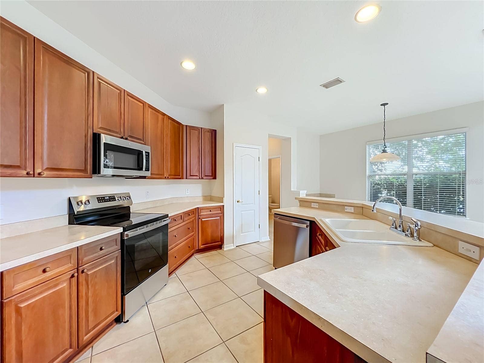 12809 HOLDENBURY LANE, Windermere, FL 34786 Wood cabinets, new appliances, closet pantry, a long breakfast bar, and ceramic tile floors