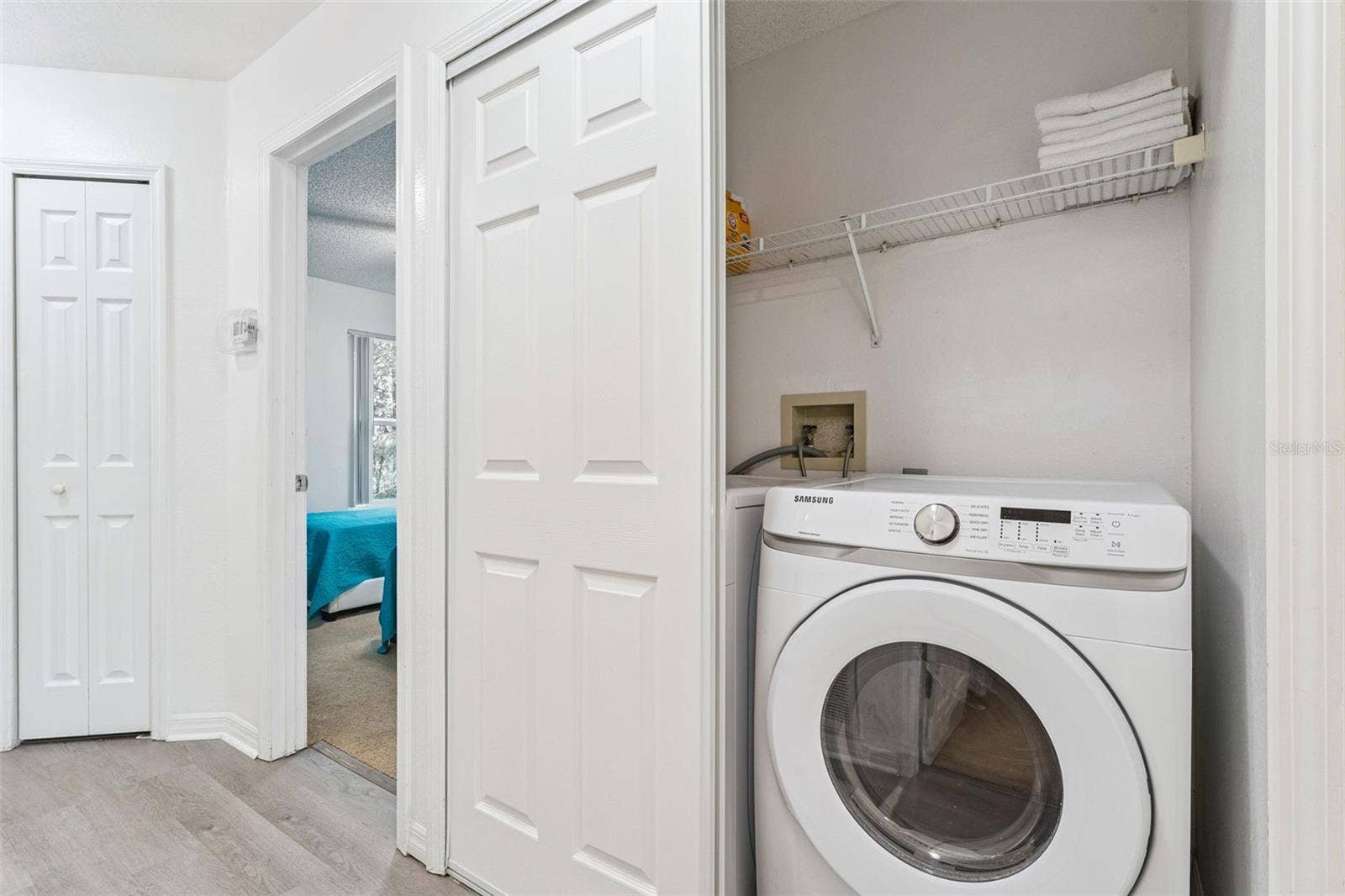 5017 LAGUNA BAY CIRCLE, #100, Kissimmee, FL 34746 In-Unit Laundry Closet: Convenient in-unit laundry closet featuring a front-loading Samsung washer and built-in wire storage shelving