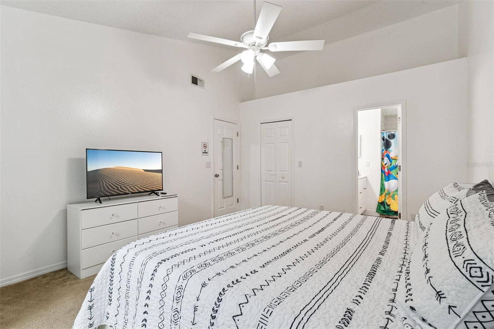 5017 LAGUNA BAY CIRCLE, #100, Kissimmee, FL 34746 Primary Bedroom Suite View: Primary bedroom view looking toward the double closet doors and private ensuite bathroom access.