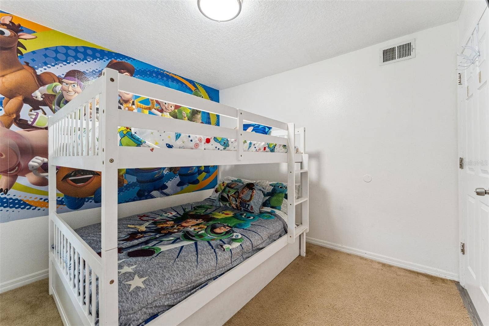 5017 LAGUNA BAY CIRCLE, #100, Kissimmee, FL 34746 Bunk Bed Room: Fun character-themed guest room equipped with sturdy white wooden bunk beds and plush carpeting.