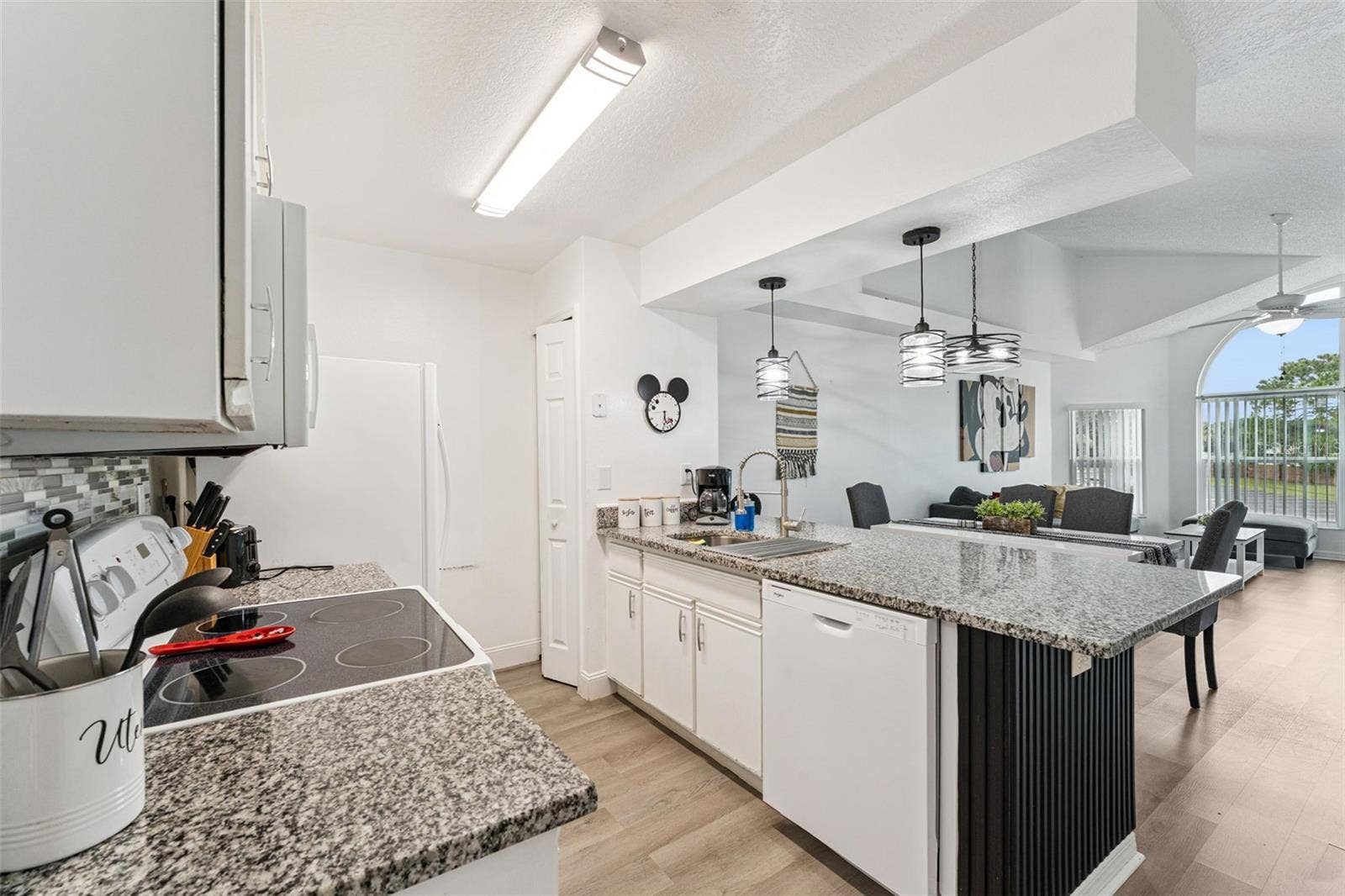 5017 LAGUNA BAY CIRCLE, #100, Kissimmee, FL 34746 Open Kitchen Perspective: Open-concept kitchen layout showing the smooth transition into the main living and dining spaces, ideal for hosting and daily living.
