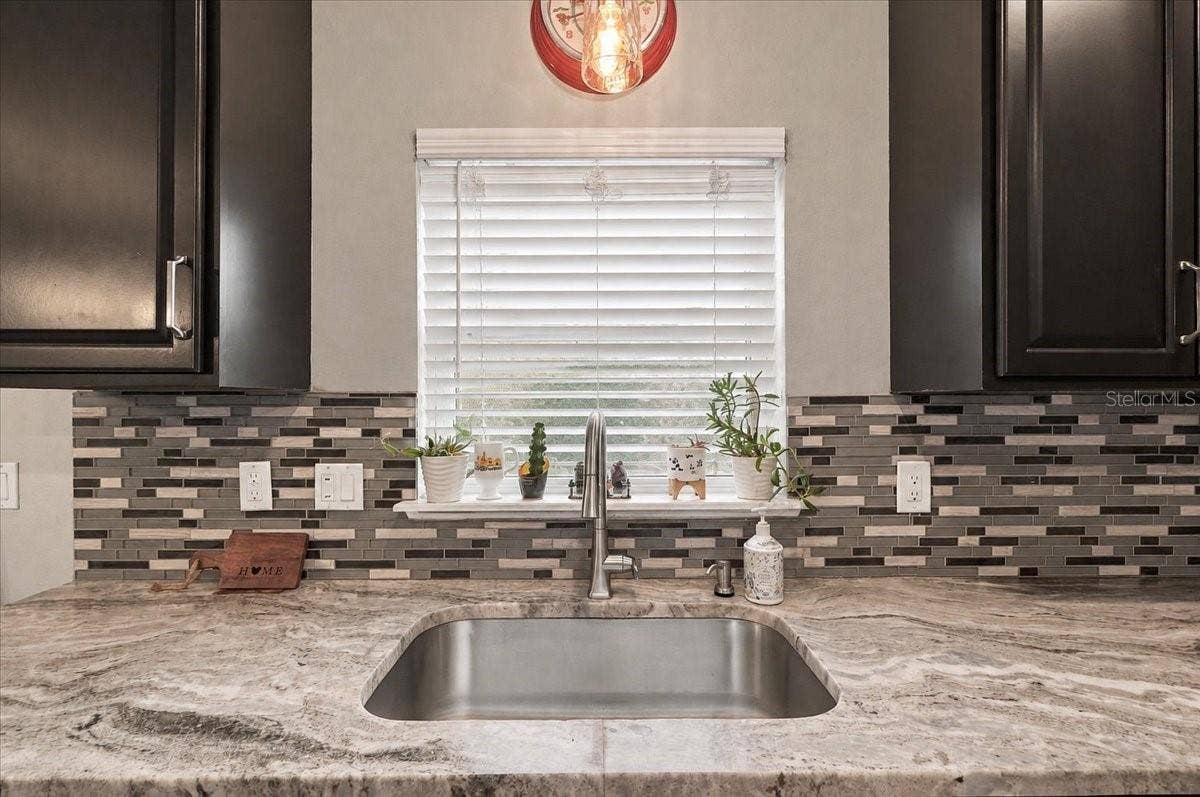 Mable countertops with view to the backyard & deep stainless steel sink.