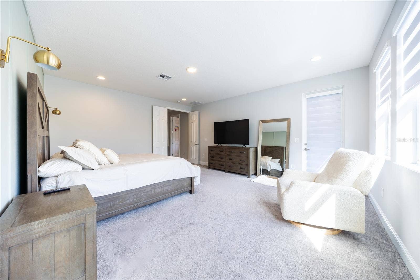 1316 SOUTHERN SUN DRIVE, Oakland, FL 34787 Spacious primary bedroom with a sitting area, double-door entry, and direct porch access.