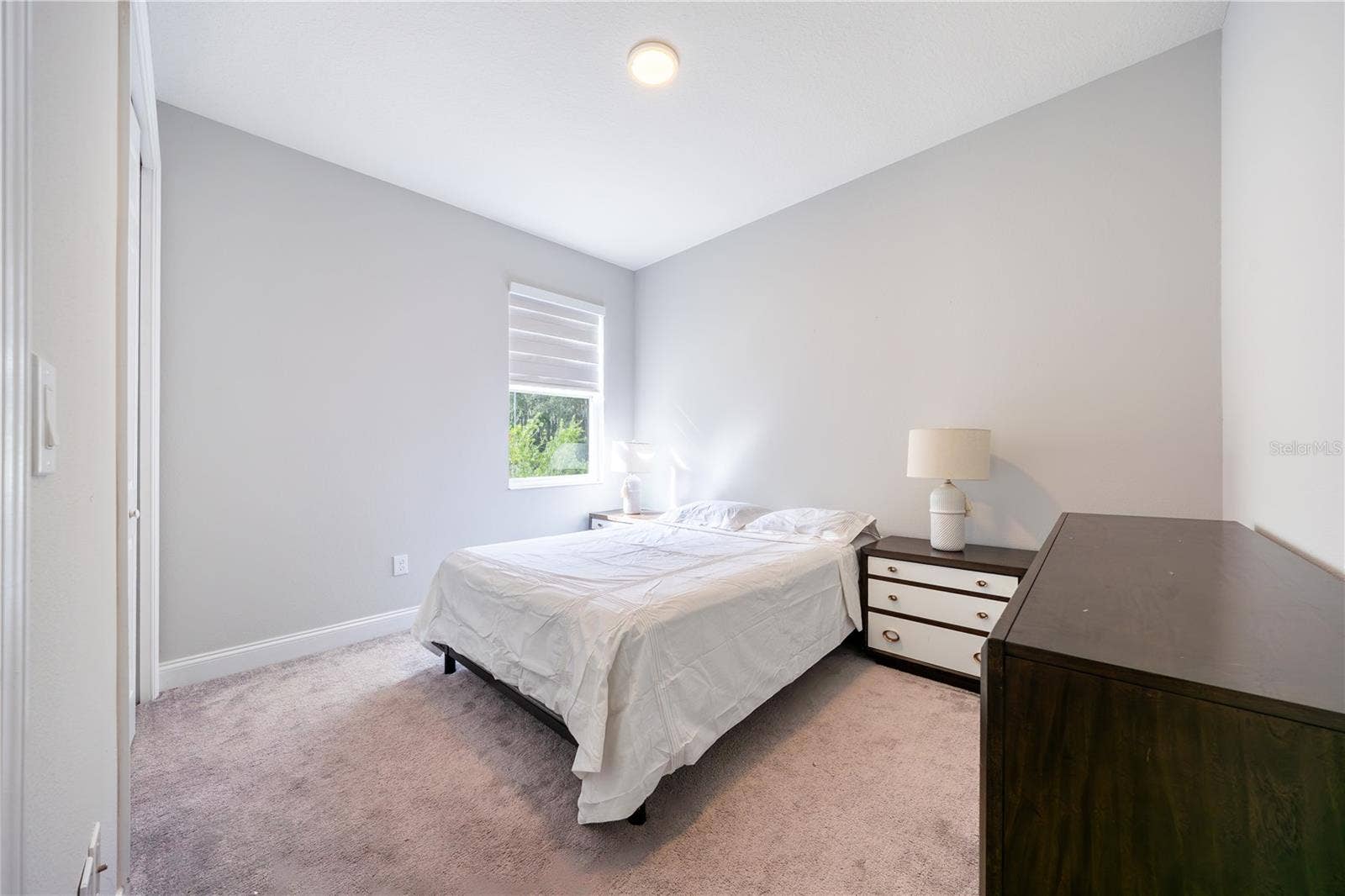 1316 SOUTHERN SUN DRIVE, Oakland, FL 34787 Comfortable bedroom with soft carpeting and a soothing neutral palette.