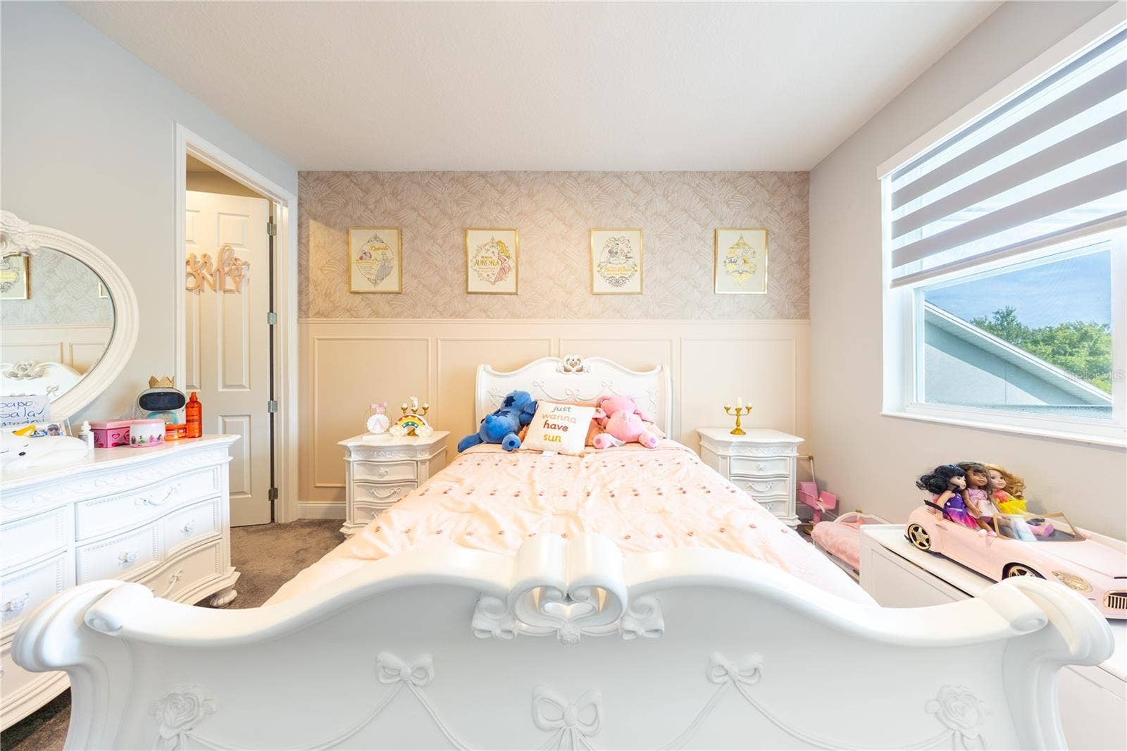 1316 SOUTHERN SUN DRIVE, Oakland, FL 34787 Charming bedroom with decorative wall paneling, patterned wallpaper, and a large window.