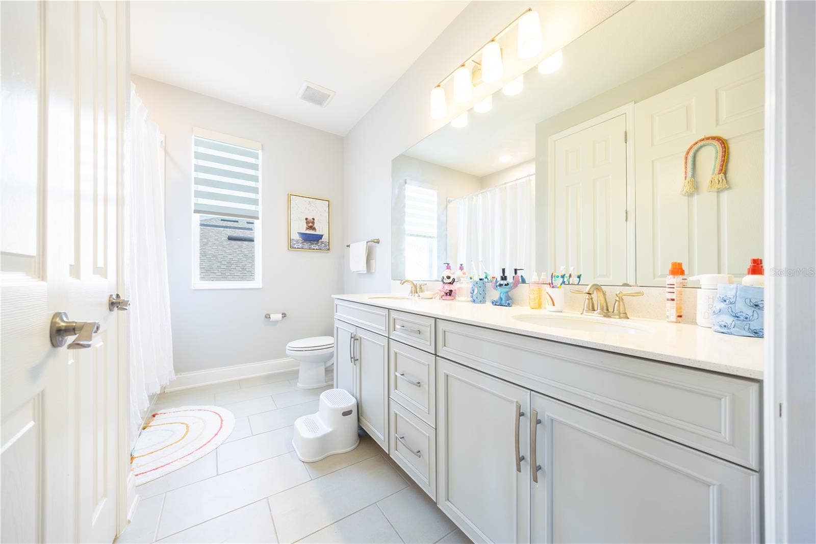 1316 SOUTHERN SUN DRIVE, Oakland, FL 34787 Spacious bathroom with a dual-sink vanity, expansive mirror, and ample cabinet storage.