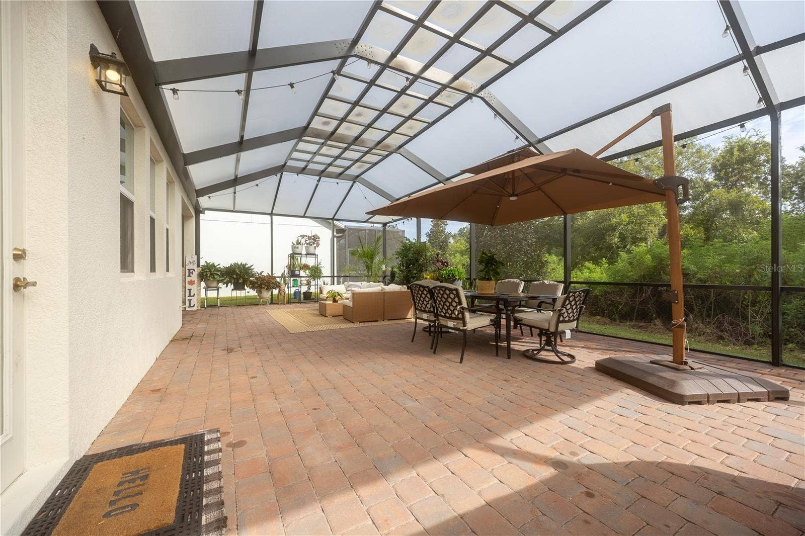 1316 SOUTHERN SUN DRIVE, Oakland, FL 34787 Expansive screened patio with paver flooring, outdoor dining, and peaceful conservation views.