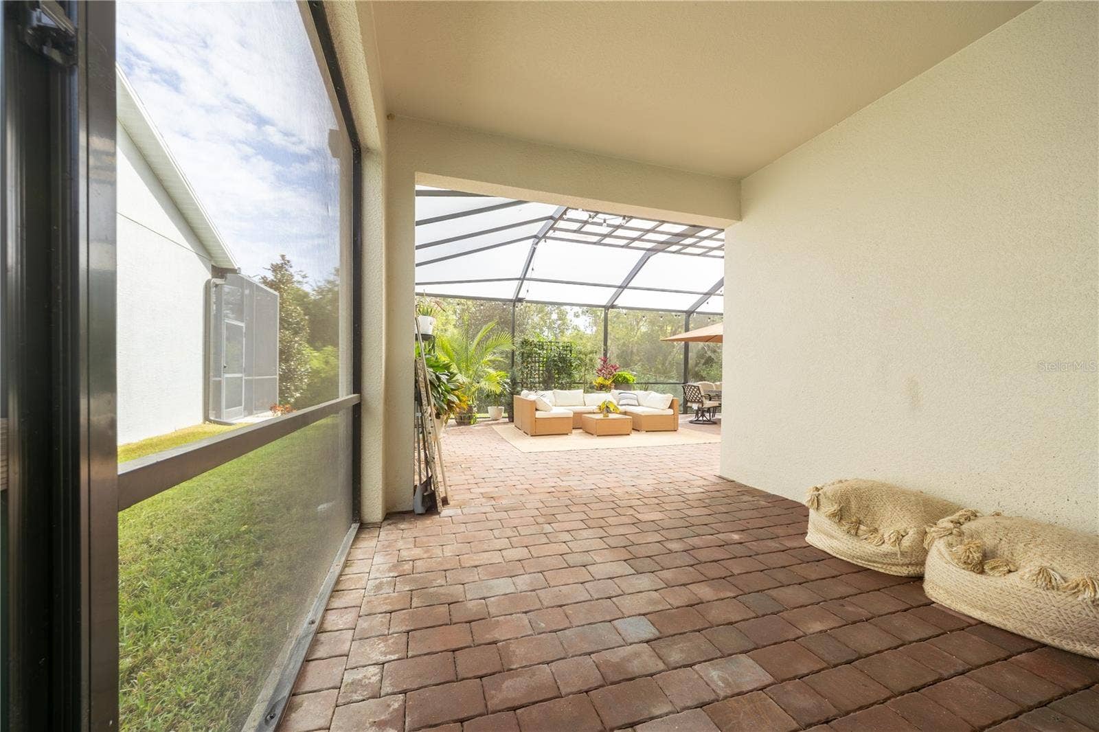 1316 SOUTHERN SUN DRIVE, Oakland, FL 34787 Covered lanai with paver flooring opening to an expansive screened patio with lounge and dining areas.
