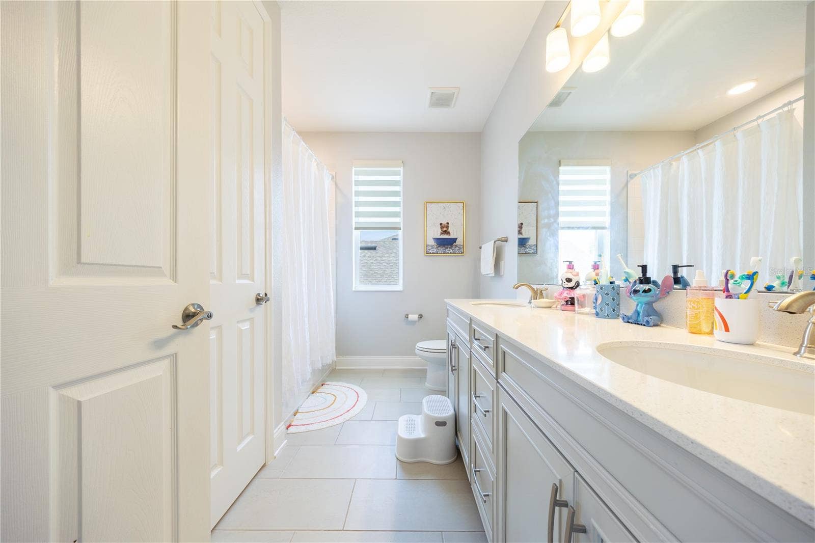 1316 SOUTHERN SUN DRIVE, Oakland, FL 34787 Well-appointed bathroom with a dual-sink vanity, ample storage, and a tub-shower combination.