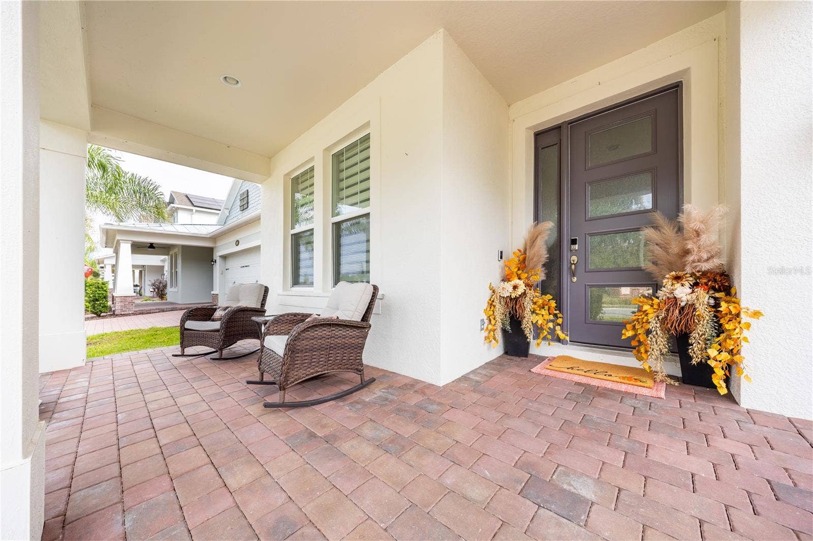 1316 SOUTHERN SUN DRIVE, Oakland, FL 34787 Inviting covered front porch with seating and a stylish entry door.