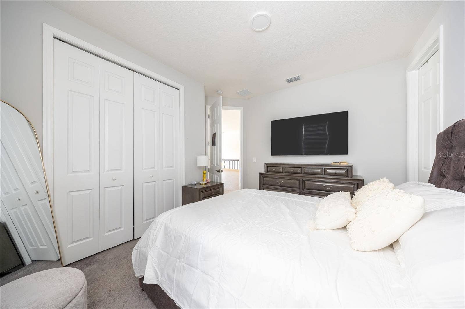 1316 SOUTHERN SUN DRIVE, Oakland, FL 34787 Comfortable bedroom with a spacious closet, soft carpeting, and a refined neutral palette.