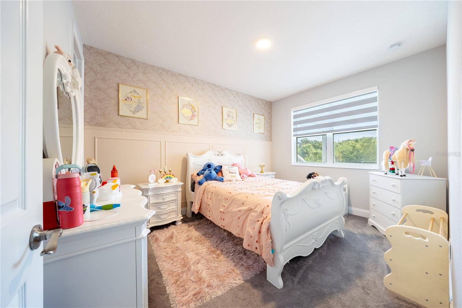 1316 SOUTHERN SUN DRIVE, Oakland, FL 34787 Inviting bedroom with a decorative accent wall, soft carpeting, and views of nature.