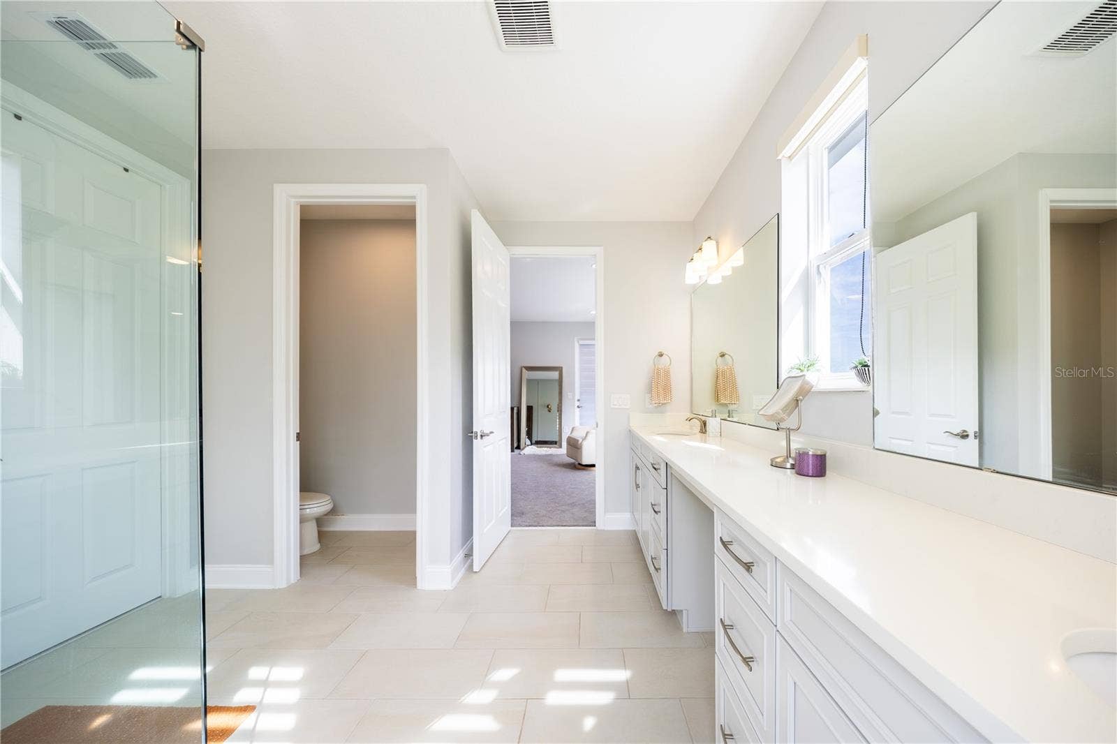 1316 SOUTHERN SUN DRIVE, Oakland, FL 34787 Elegant primary bathroom with an expansive vanity, makeup area, and separate toilet room.