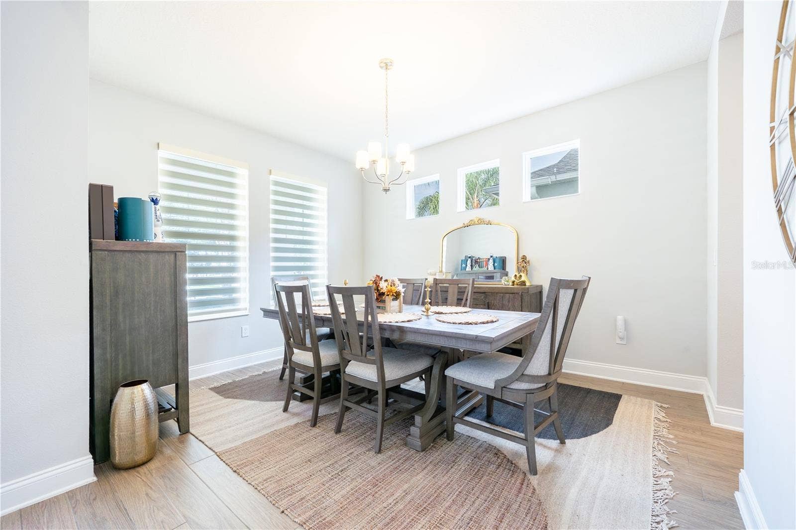1316 SOUTHERN SUN DRIVE, Oakland, FL 34787 Elegant dining room with abundant natural light and a classic chandelier.
