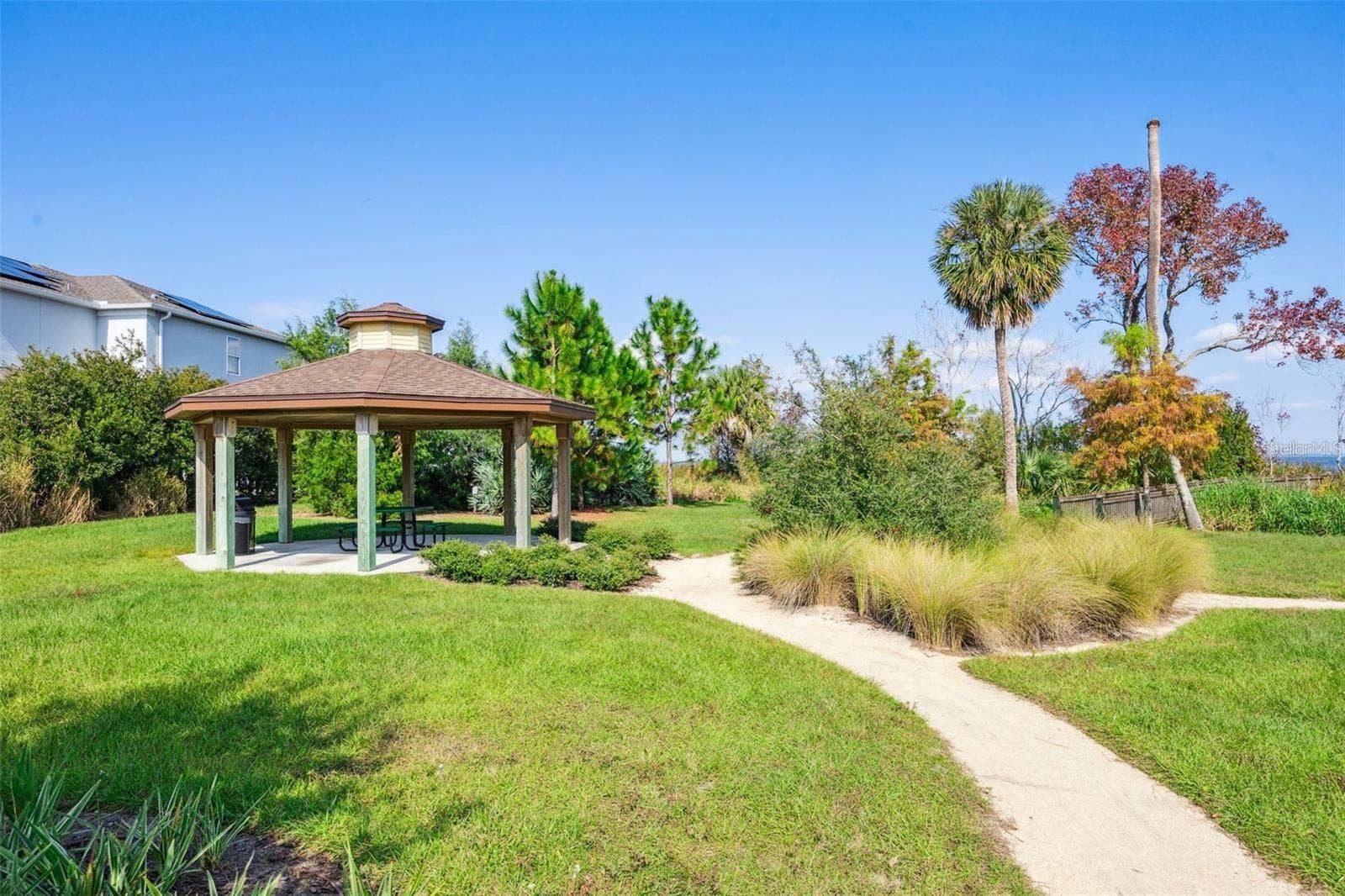 1316 SOUTHERN SUN DRIVE, Oakland, FL 34787 Covered picnic pavilion surrounded by lush landscaping, with a walking path leading toward the lake.