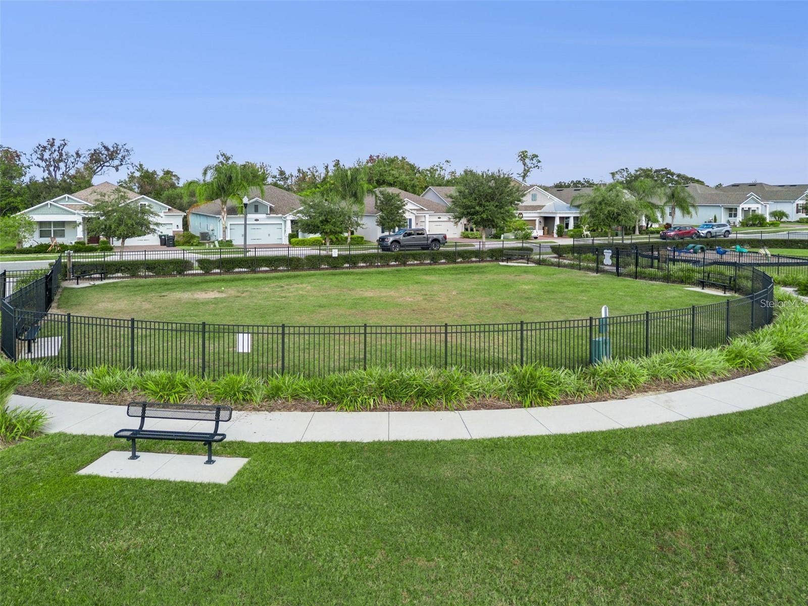 1316 SOUTHERN SUN DRIVE, Oakland, FL 34787 Fenced dog park with an open lawn, seating benches, and surrounding walking paths.