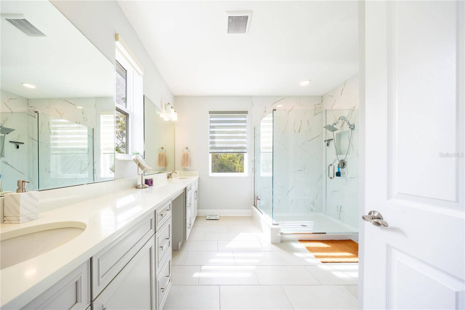 1316 SOUTHERN SUN DRIVE, Oakland, FL 34787 Spacious primary bathroom with a dual-sink vanity, makeup area, and frameless glass shower.