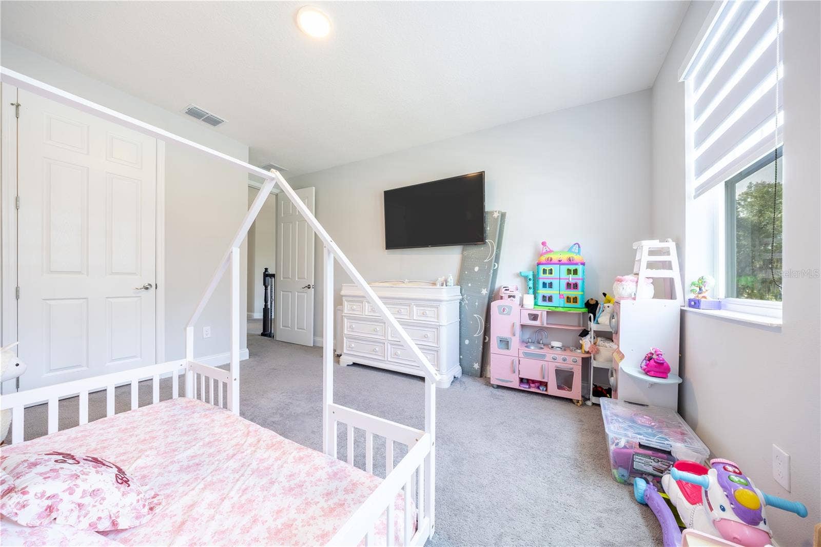 1316 SOUTHERN SUN DRIVE, Oakland, FL 34787 Comfortable bedroom with soft carpeting, a double-door closet, and space for a play area.