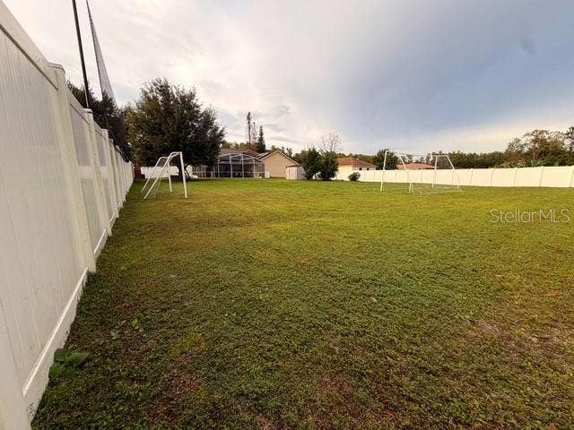 View of the half acre (over 21,000 square feet) LOT, all fenced in White vinyl fence.; Is so large that they practice soccer with the two goals seen here.