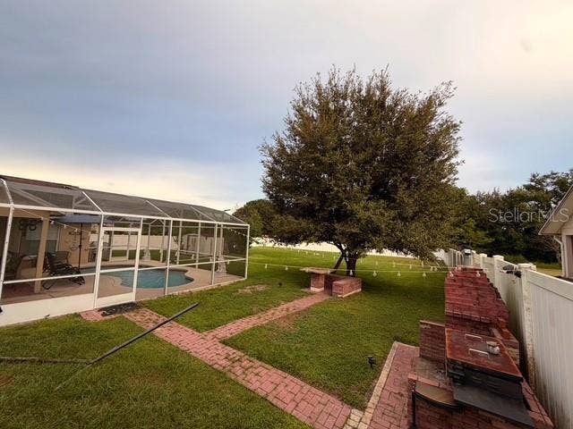 Partial Patio view outside the pool and its enclosure, you can see the external BBQ and kitchen area and the picnic table under the tree