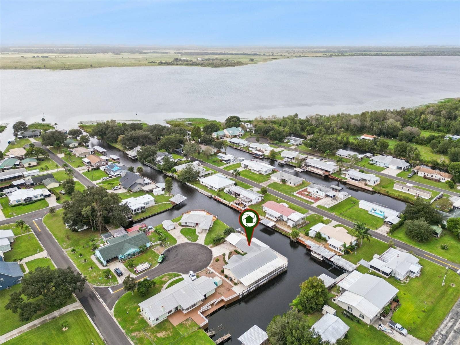 Aerial Property Location Pin: Neighborhood aerial view featuring a target pin identifying the home's location relative to the nearby lake