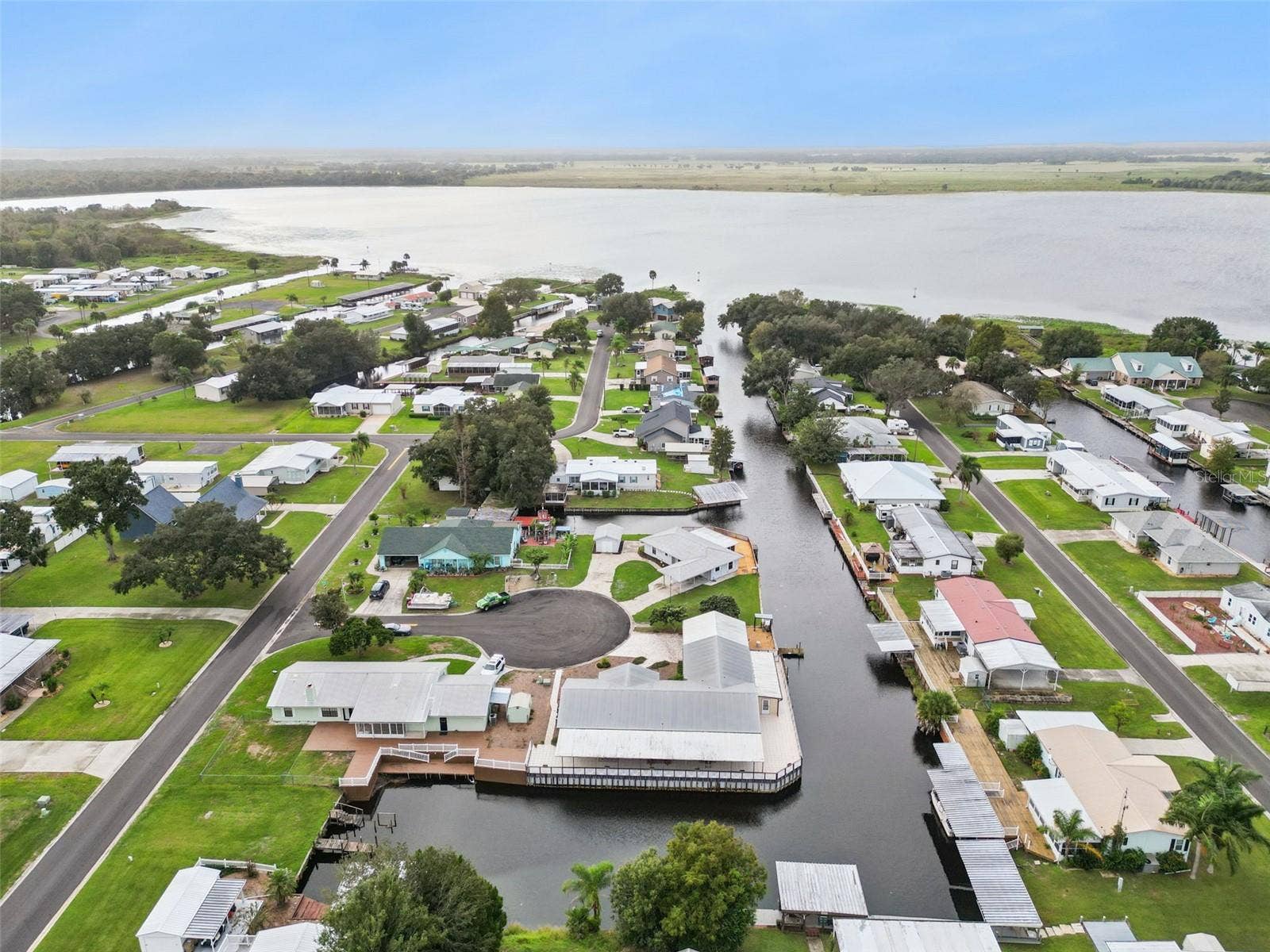 Neighborhood Aerial & Lake View: Wide aerial overview displaying the surrounding waterfront community and proximity to the expansive lake system