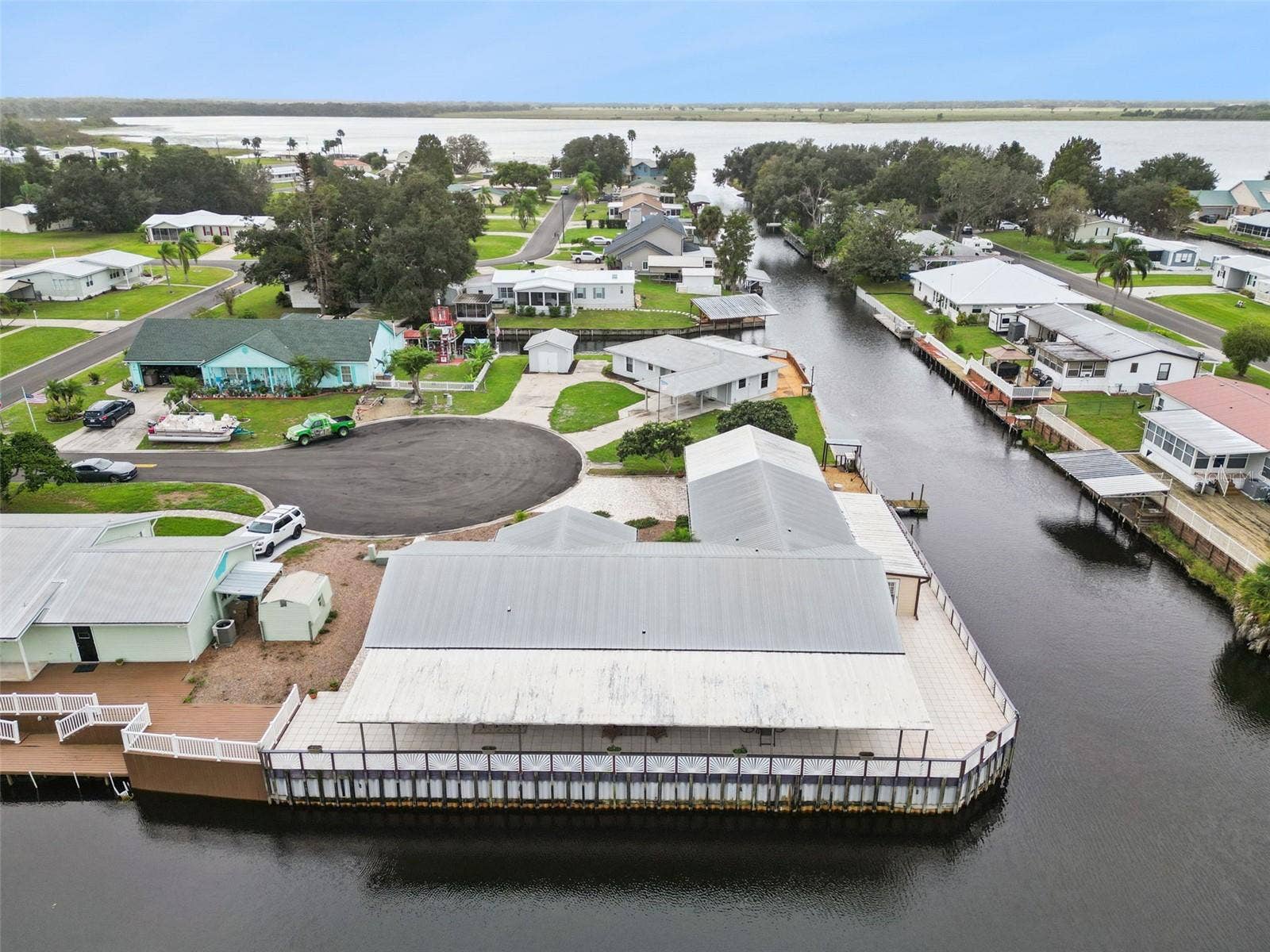 Aerial View Toward Lake: Elevated aerial shot highlighting the home's direct canal access leading out to the adjacent lake open water.