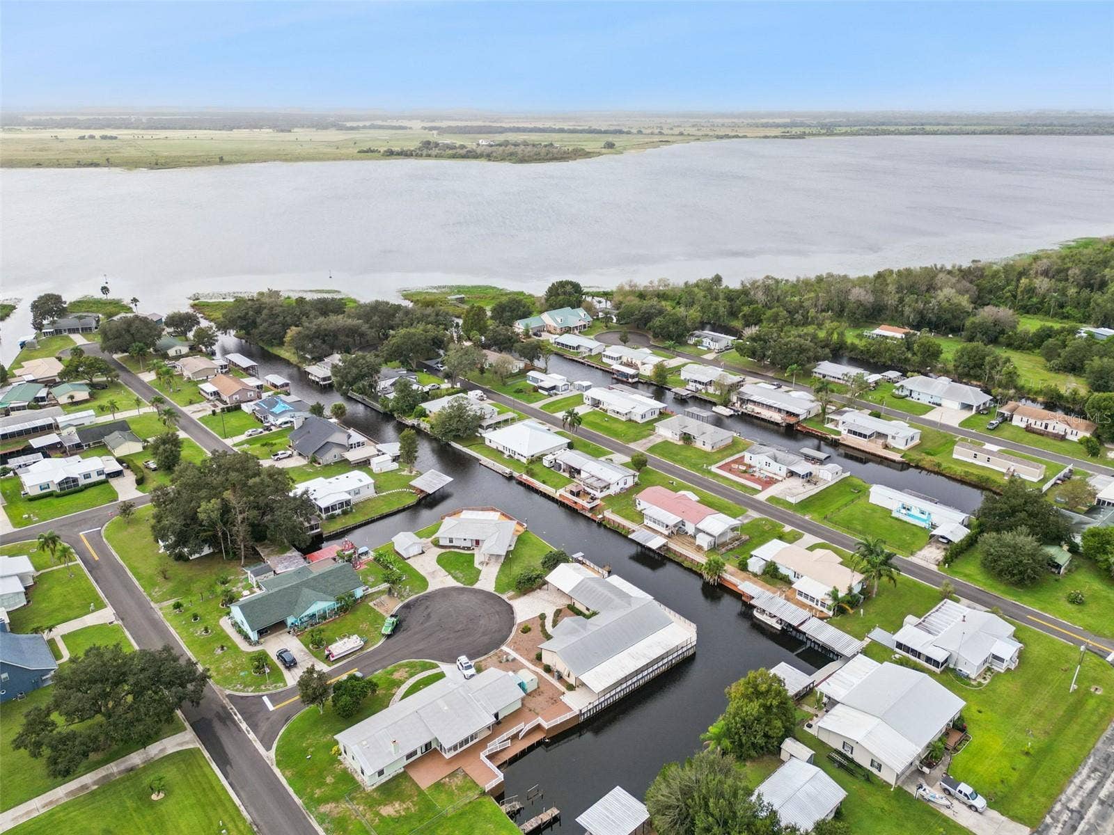 Aerial Location Overview: Wide neighborhood drone perspective highlighting the home's premier position on the canal.
