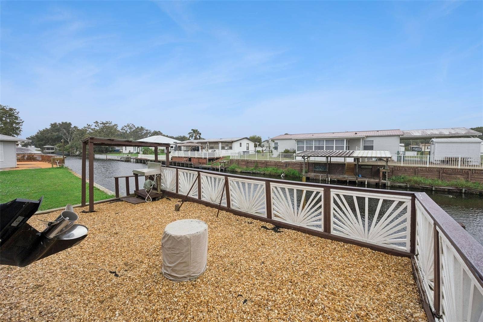 Gravel Waterfront Patio Deck: Spacious low-maintenance gravel patio area enclosed by decorative railings right by the water