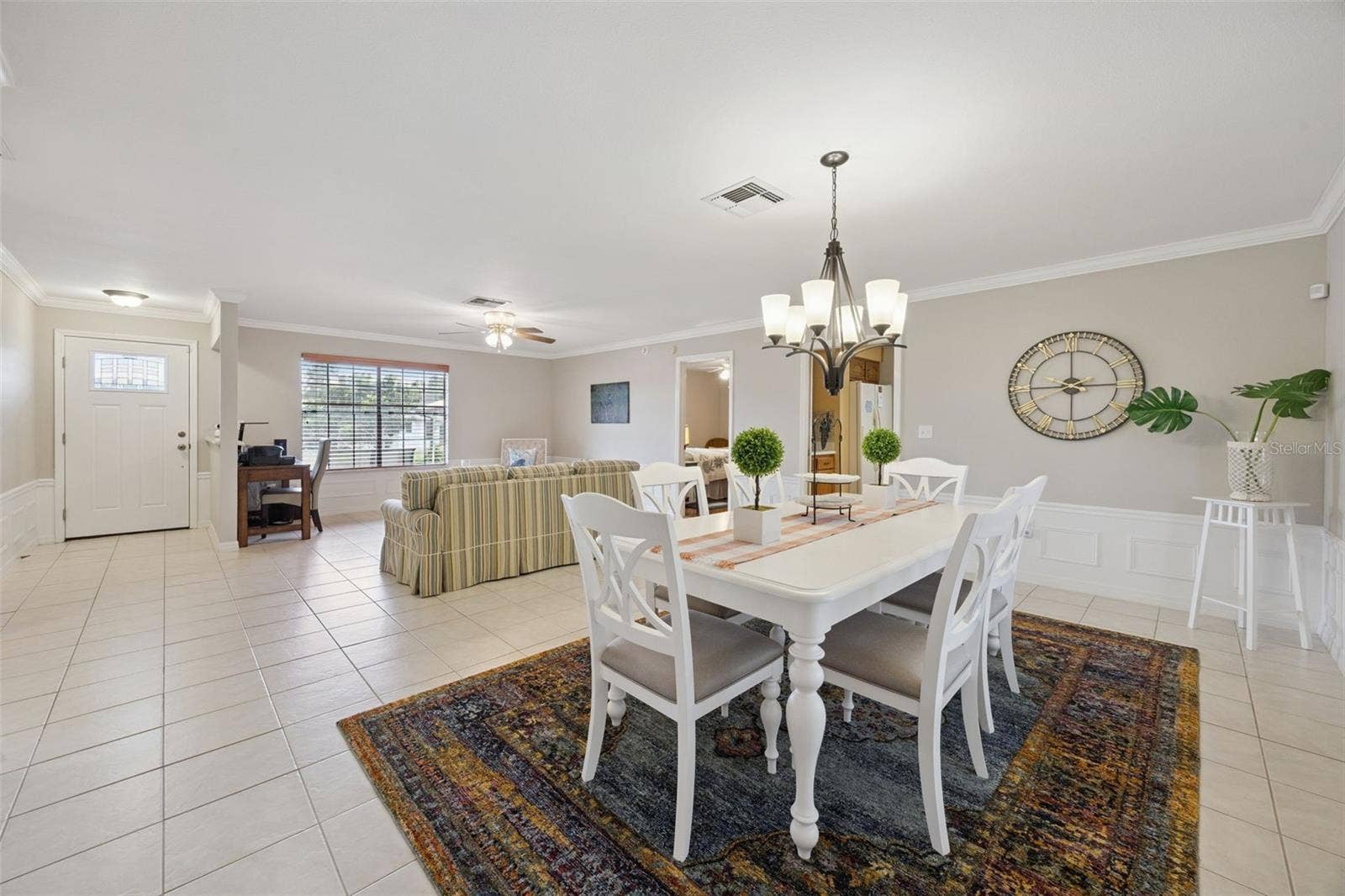 Open Living & Dining Area: Generous open-concept living space linking the main entry, formal dining area, and living room with easy-maintenance ceramic tile throughout.