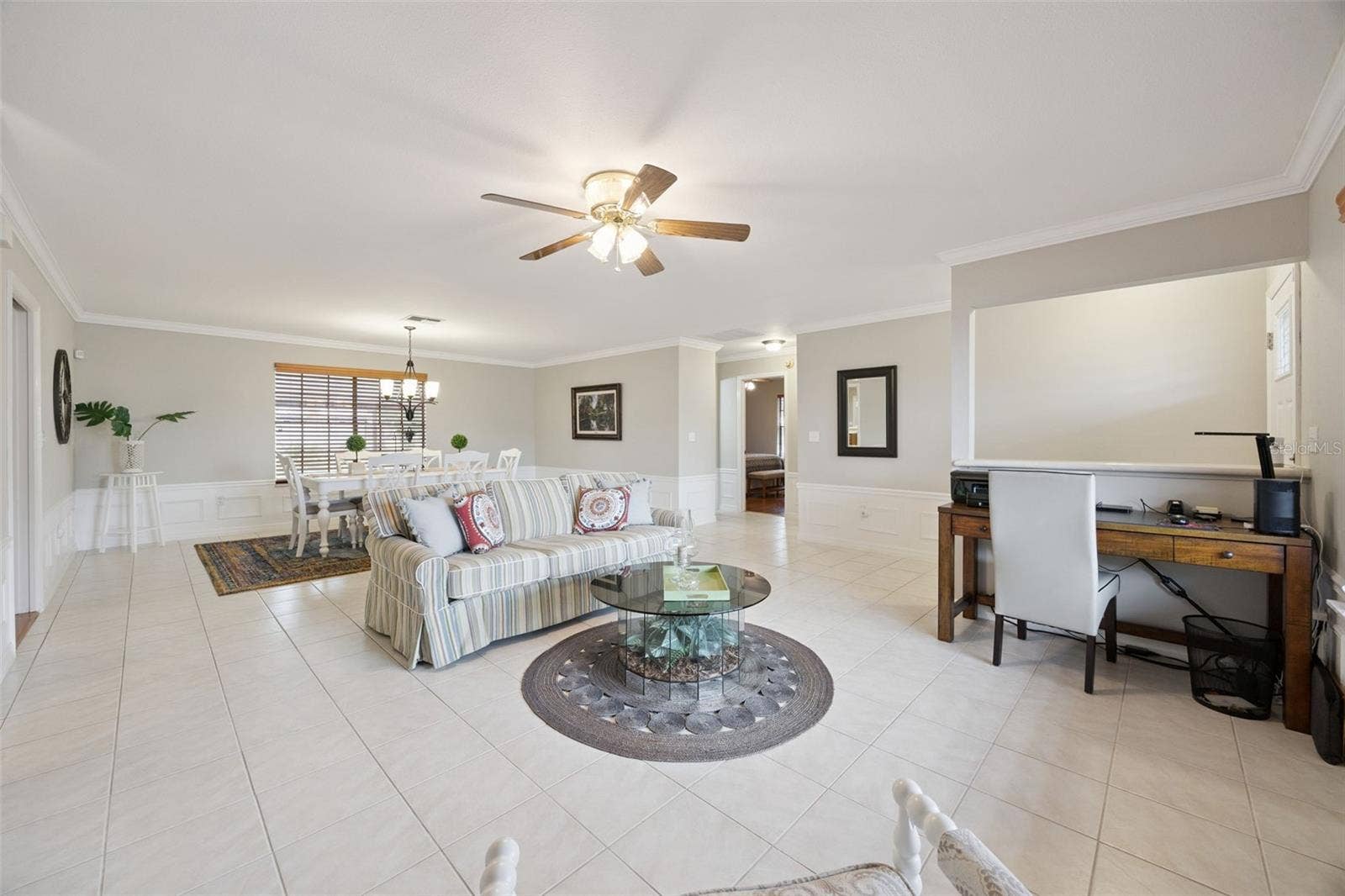 Great Room & Home Office Nook: Versatile main living area featuring neutral wall tones, tile floors, formal dining area, and a dedicated desk workspace nook.