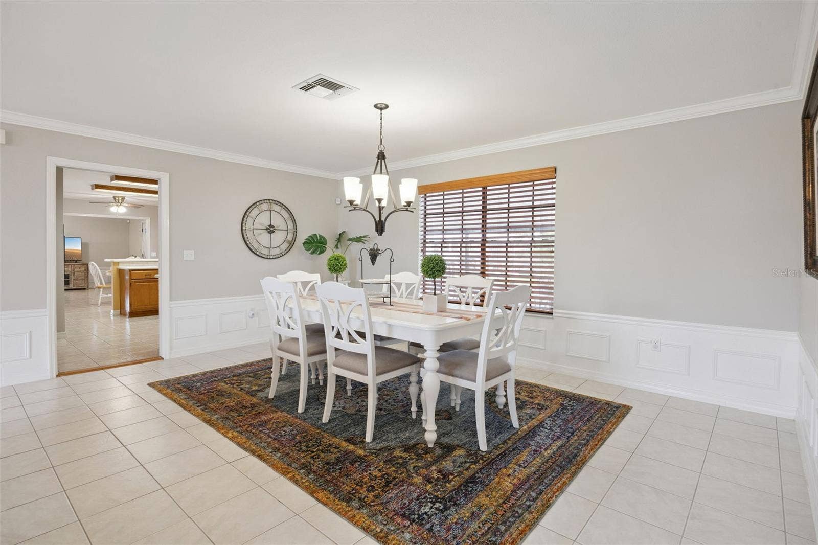 Formal Dining Alternate View: Spacious formal dining room highlighted by detailed wall molding, bright natural light, and convenient access to adjacent living spaces.