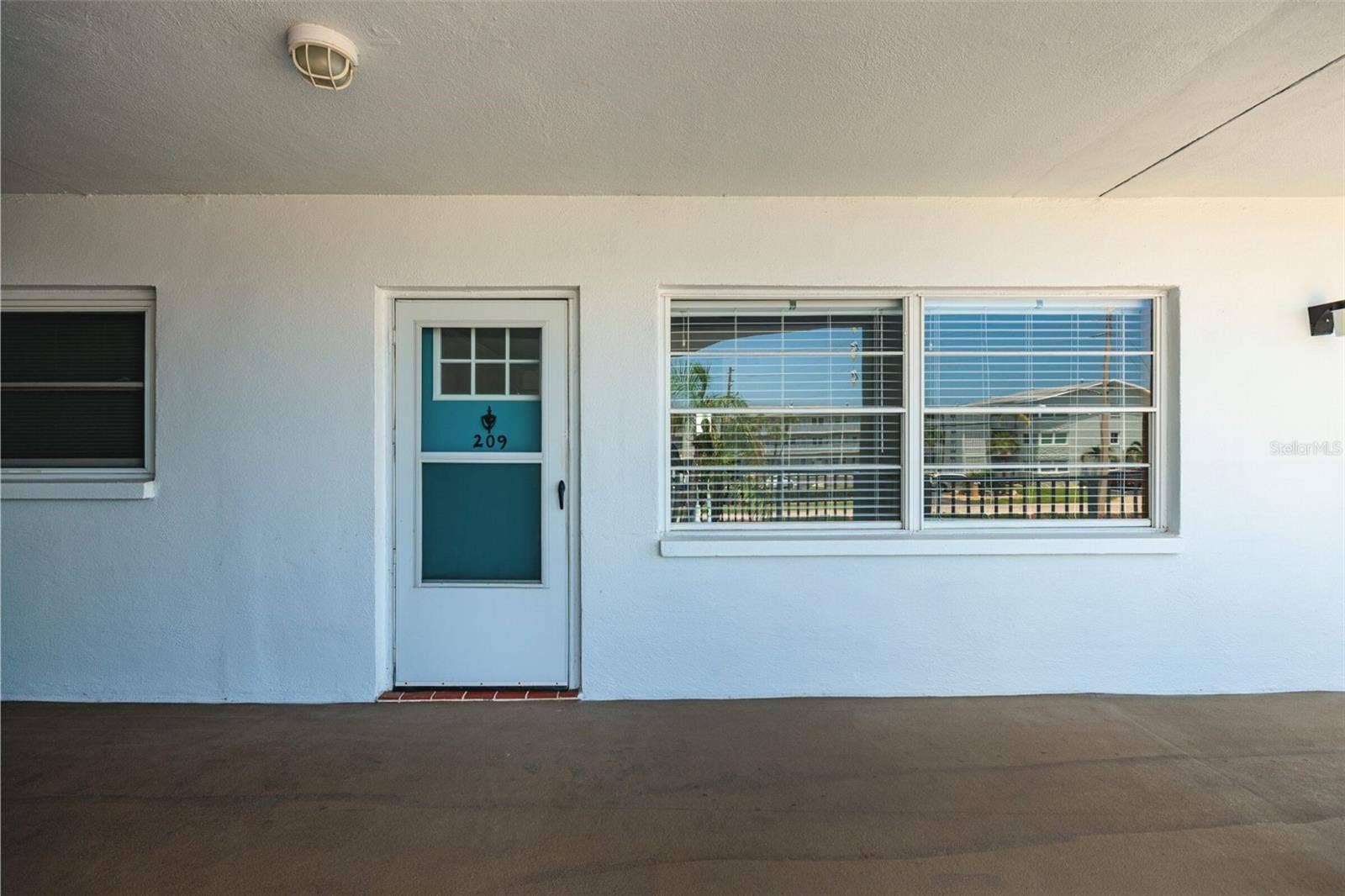 1893 SHORE DRIVE S, #209, South Pasadena, FL 33707 Exterior Front faces NW. Large overhang slab ceiling to protect from rain outside the front door.